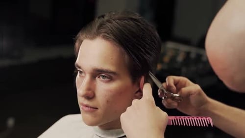 close-up of a haircut master cutting with scissors