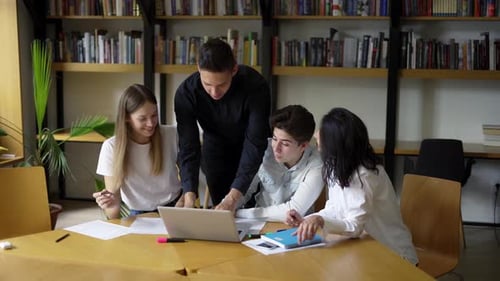 Groupe d'étudiants : des lycéens se réunissent dans la bibliothèque du collège pour discuter de sujets sur lesquels travailler ensemble