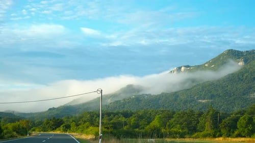 Driving Along a Foggy Mountain Road at Sunrise