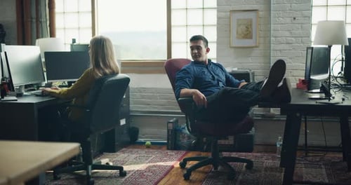 Employees Goof Around At The End Of The Day In Modern Well Lit Office During The Day. Wide To Lon...