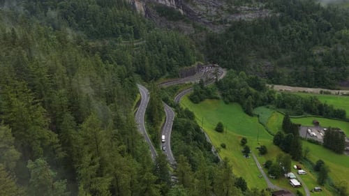 Red Car Driving on Winding Mountain Road in Switzerland