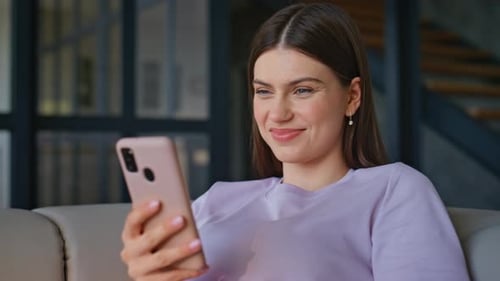 Woman Using Smartphone While Relaxing on Couch