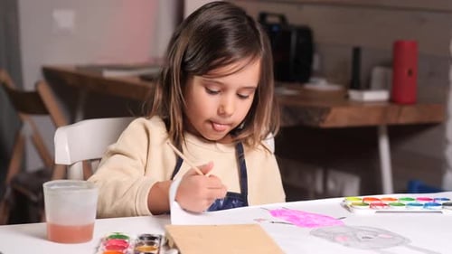 Girl Painting Watercolors on Paper at Home