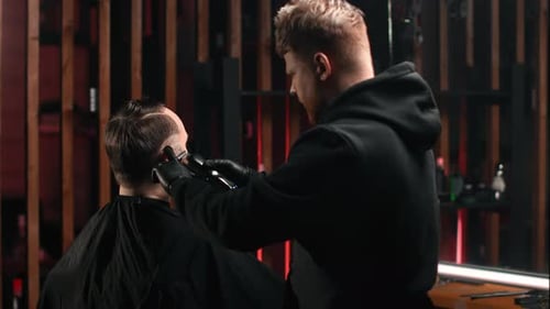 Barber Cuts Man's Hair in Modern Barbershop