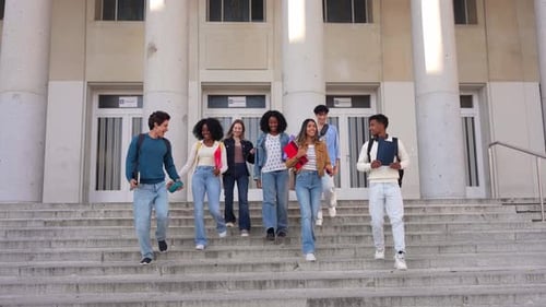 Happy Multiracial Group of Students Walking Down University Steps Together