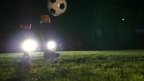 Athlete Juggling Soccer Ball at Night on Field