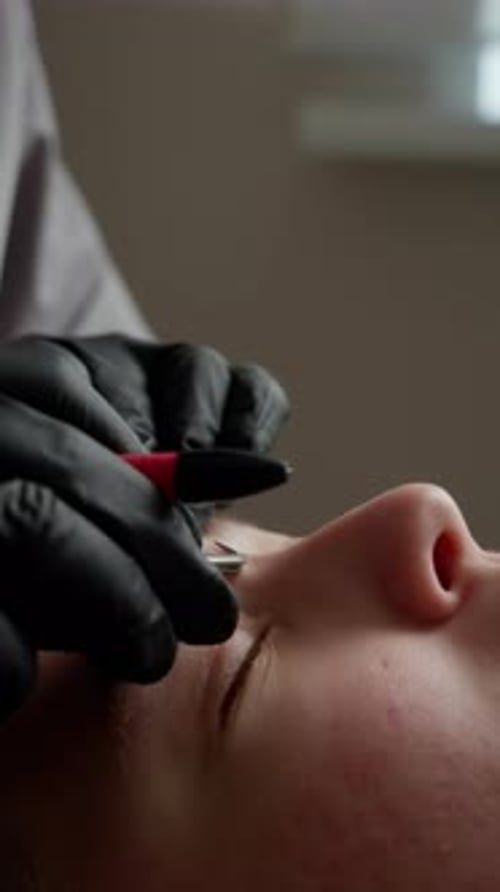 Eyebrow Shaping With Silver Tweezers Close Up Vertical