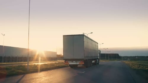 Follow-up Shot of a Semi-Truck with Cargo Trailer Moving on a Highway. White Truck Drives Through I