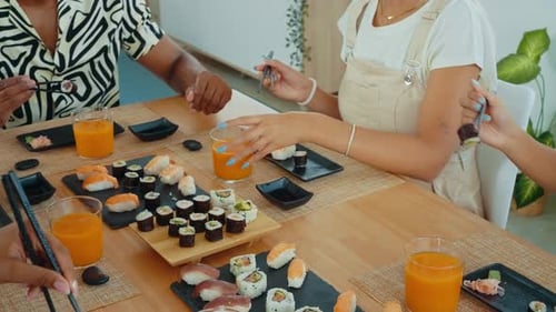 Group of friends eating sushi together at home.