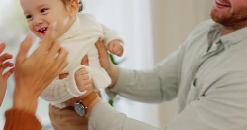 Father and Mother Playing with Happy Baby Indoors