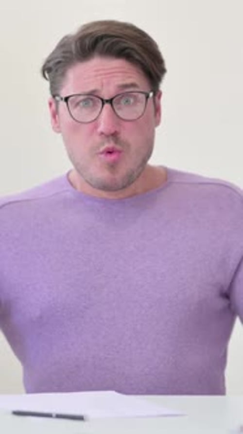 Concerned Man Explains Something While Sitting at Desk