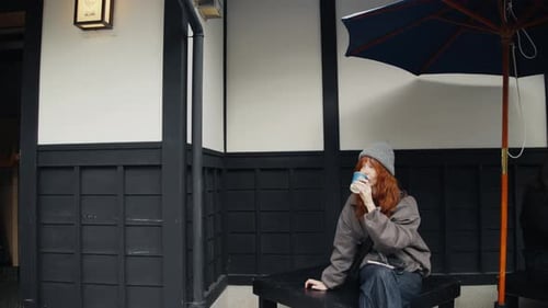Young Woman Relaxing with Coffee in Urban Setting
