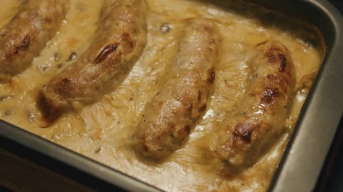 Sausages in Creamy White Sauce Baked in the Oven Close Up