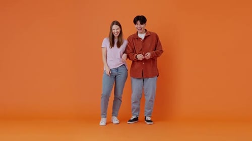 Un couple joyeux composé d'une dame et d'un gars rit d'une blague d'un ami