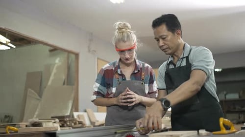 Carpenters are working together at workshop.