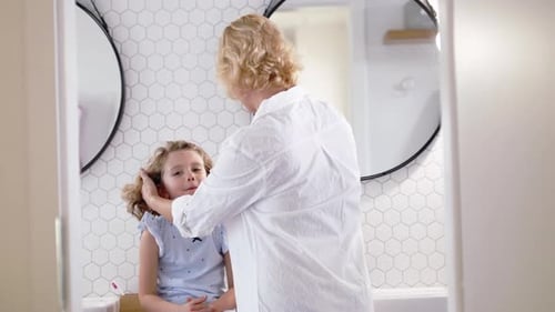 Woman caring for child in bathroom at home