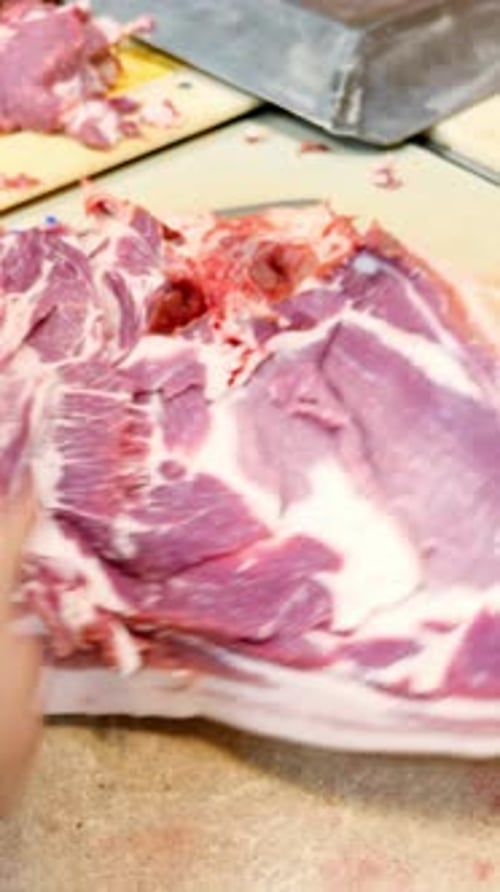 Butcher Preparing Fresh Meat on a Cutting Board with Tools and Vibrant Colors in a Kitchen Setting