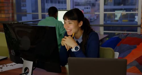 Femme d'affaires faisant un appel vidéo sur ordinateur dans un bureau moderne