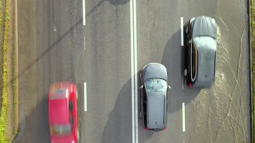 Luftaufnahme des Stadtverkehrs mit Autos, die nach starkem Regen auf überfluteter Straße fahren