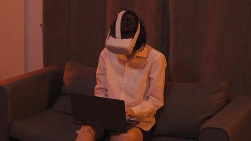 Woman Wearing VR Headset Interacting with Laptop
