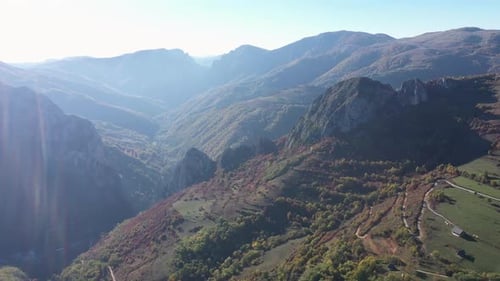 Flying over misty autumn mountains and colorful forest aerial by drone