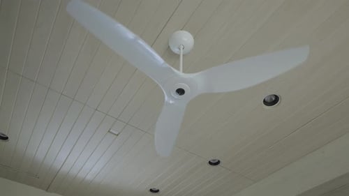White Ceiling Fan Rotating Slowly in Modern Home