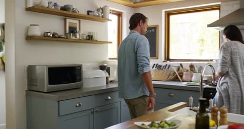 Couple Cooking and Feeding Each Other in Kitchen