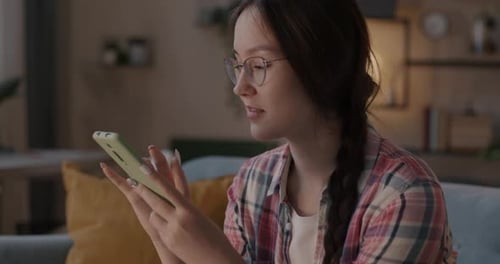 Young Woman Uses Smartphone in Living Room