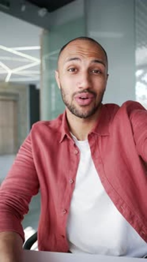 POV Vertical. Smiling businessman talking on video call using phone in business office.