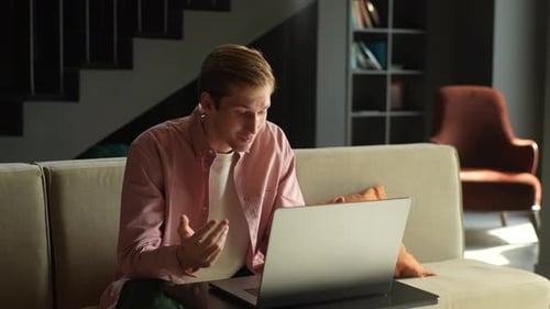 Young Man Video Chatting on Laptop from Home
