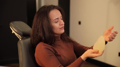Woman Examines Silicone Breast Implant in Office
