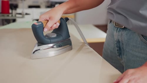 Female Creative Ironing Fabric On Pressing Table With Steam Iron Removing Wrinkles