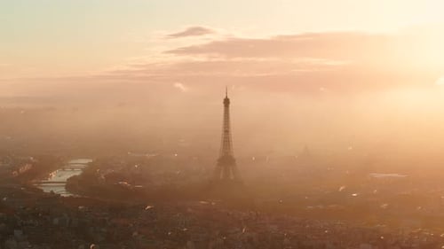 Rising circling aerial shot of the Eiffel tower Paris at sunrise