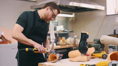 Das Material schneiden. Techniker, der im modernen Labor mit Prothesen arbeitet