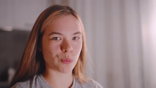 Young Woman Eating Sliced Cucumber in Kitchen Close Up