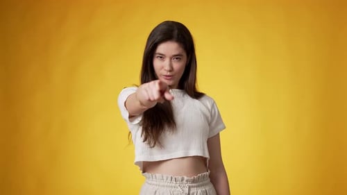 Young Adult Woman Gesturing on Yellow Background