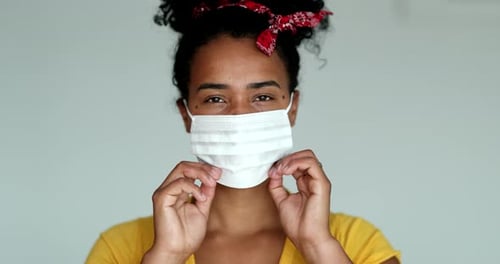 African american woman putting covid-19 face mask prevention against disease