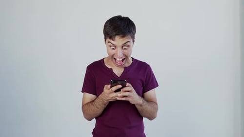 Man Reacts to Phone With Joyful Surprise