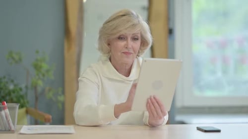 Cheerful Senior Old Woman using Tablet PC