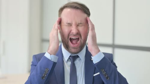 Adult Man Experiencing a Headache in Workplace