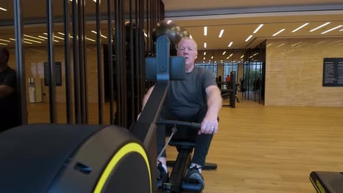 Male Pulling On A Rowing While Exercising Cardio Strength In A Gymnasium, Before Moving On.