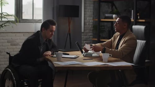 Two Directors of a Large Company are Sitting at a Table in the Office and Studying the Company's