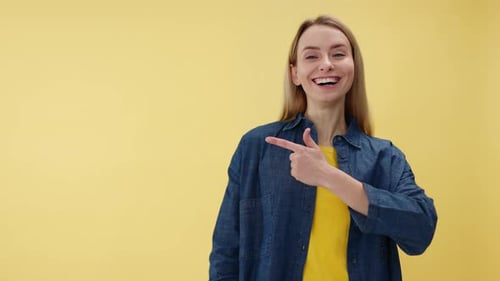 Smiling Woman Pointing to the Left on Yellow