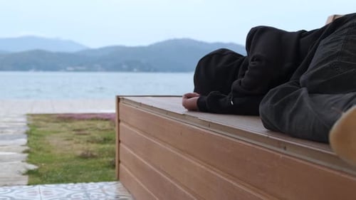 Two People Relaxing on Bench by the Beach