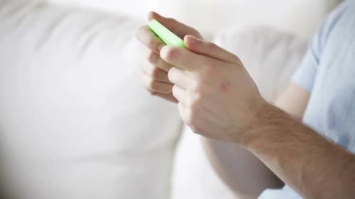 Man Plays Game on Phone While Sitting