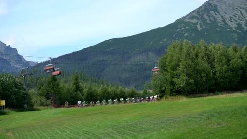 Scenic Mountain Landscape with Ski Lift and Bikers
