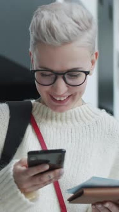 Woman Checking her Flight Information in Busy Airport