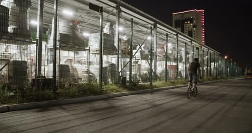Male BMX Rider Leaving After Training in Evening City
