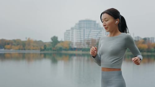 Woman Jogging in Park Checks Smart Watch