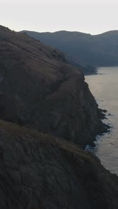 Flying Forward Over the Sea Shore at Sunrise Aerial View Vertical Video
